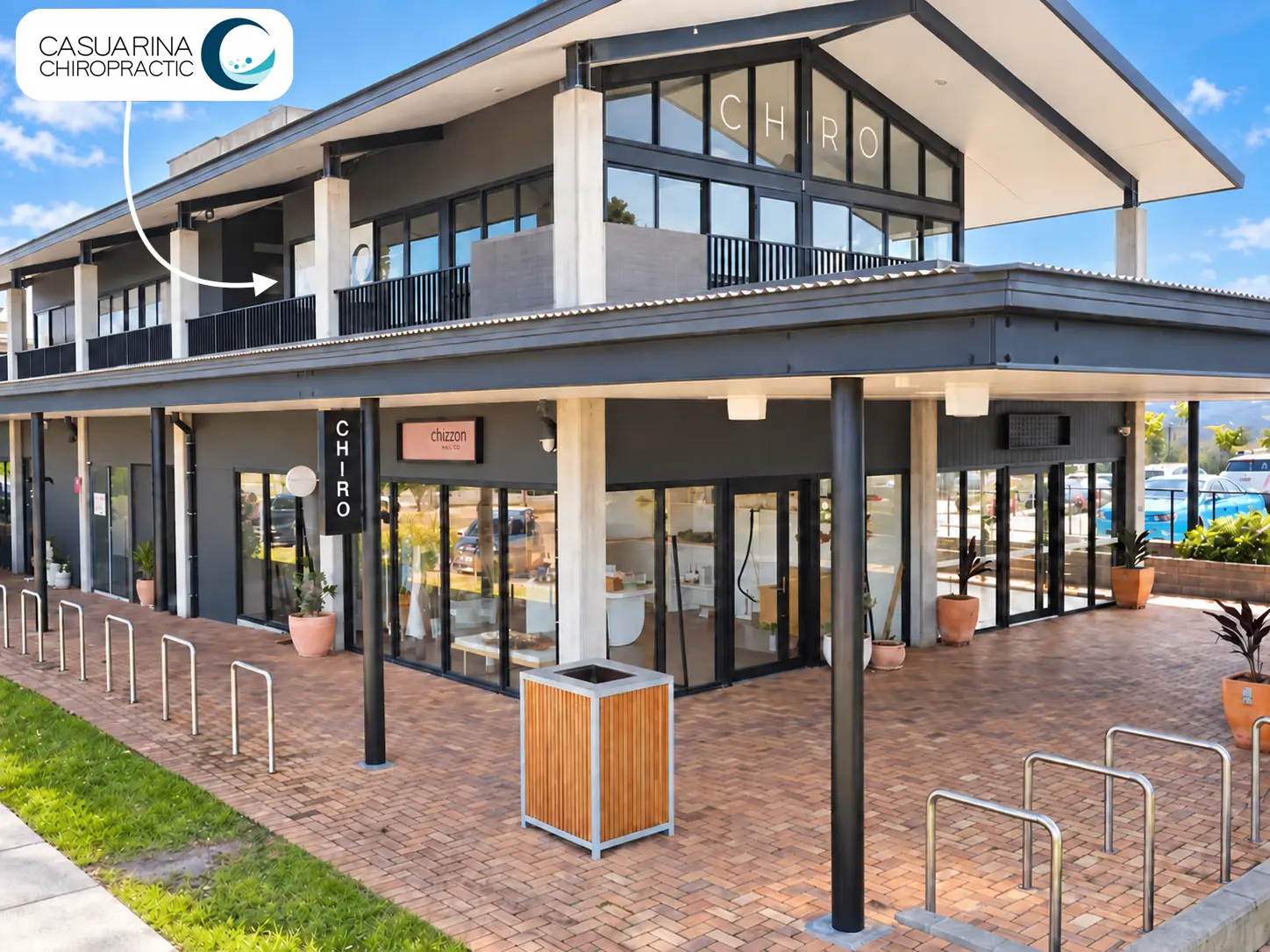 Exterior of The Commons showing the upstairs location of Casuarina Chiropractic, marked by the practice logo and an arrow.