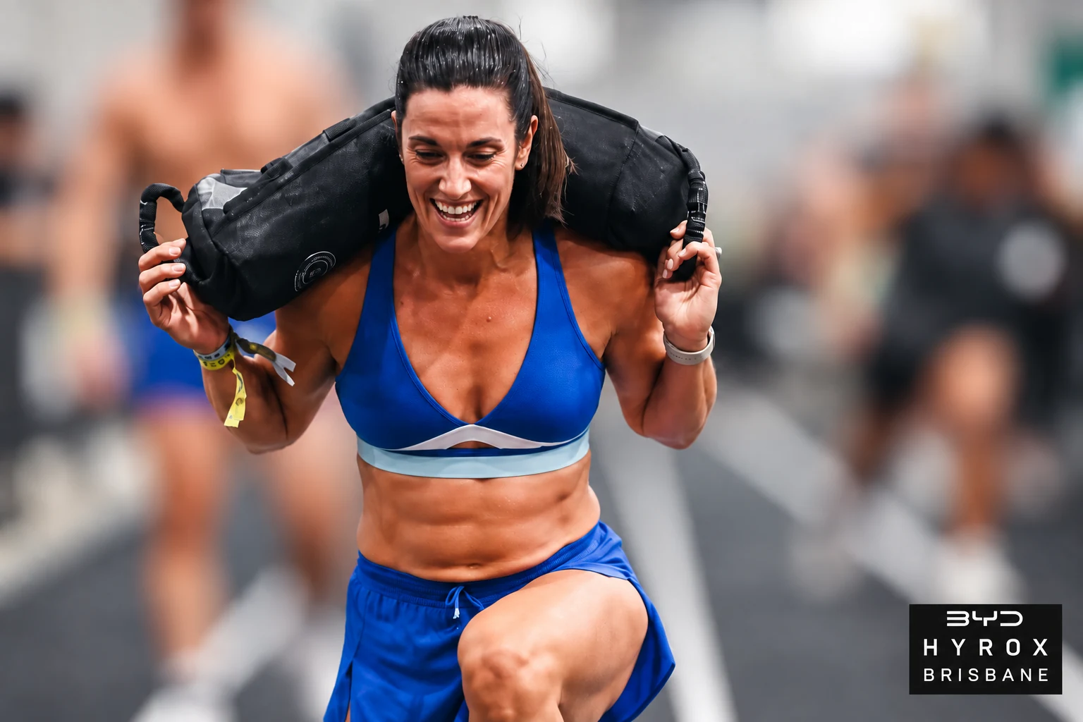 Jane competing in HYROX Brisbane, 2026, with background competitors blurred and the event logo.
